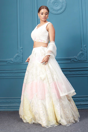 Shop an off-white floral lehenga with silver embroidery and a sleeveless blouse. Dazzle on weddings and special occasions with exquisite Indian designer dresses, sharara suits, Anarkali suits, bridal lehengas, and sharara suits from Pure Elegance Indian clothing store in the USA. Shop online from Pure Elegance.