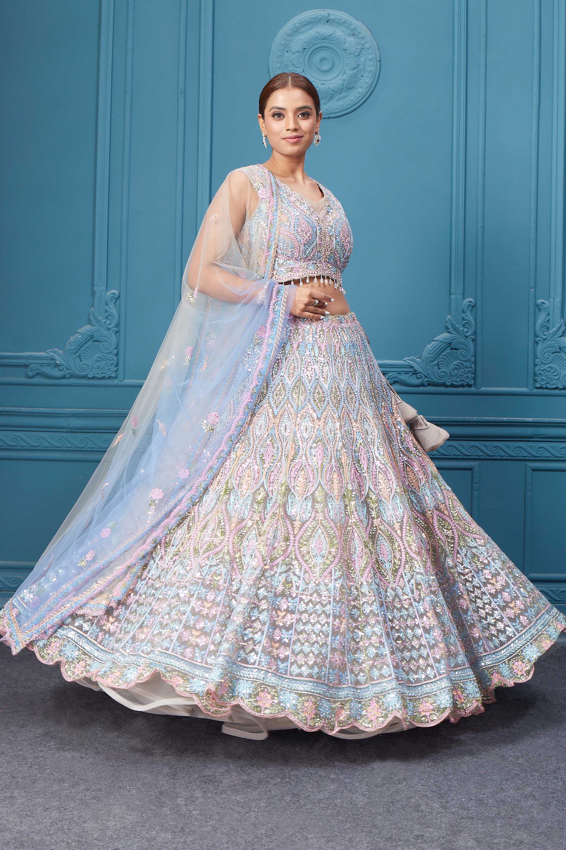 Shop this light blue and pink lehenga with heavy floral and sequin embroidery. Dazzle on weddings and special occasions with exquisite Indian designer dresses, sharara suits, Anarkali suits, bridal lehengas, and sharara suits from Pure Elegance Indian clothing store in the USA. Shop online from Pure Elegance.