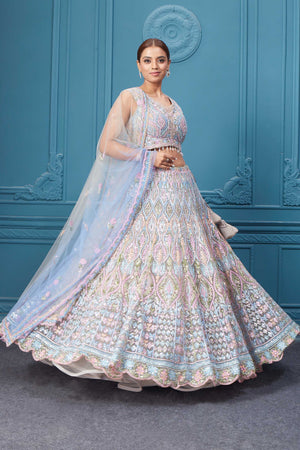 Shop this light blue and pink lehenga with heavy floral and sequin embroidery. Dazzle on weddings and special occasions with exquisite Indian designer dresses, sharara suits, Anarkali suits, bridal lehengas, and sharara suits from Pure Elegance Indian clothing store in the USA. Shop online from Pure Elegance.