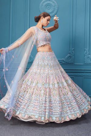 Shop this light blue and pink lehenga with heavy floral and sequin embroidery. Dazzle on weddings and special occasions with exquisite Indian designer dresses, sharara suits, Anarkali suits, bridal lehengas, and sharara suits from Pure Elegance Indian clothing store in the USA. Shop online from Pure Elegance.