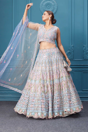 Shop this light blue and pink lehenga with heavy floral and sequin embroidery. Dazzle on weddings and special occasions with exquisite Indian designer dresses, sharara suits, Anarkali suits, bridal lehengas, and sharara suits from Pure Elegance Indian clothing store in the USA. Shop online from Pure Elegance.