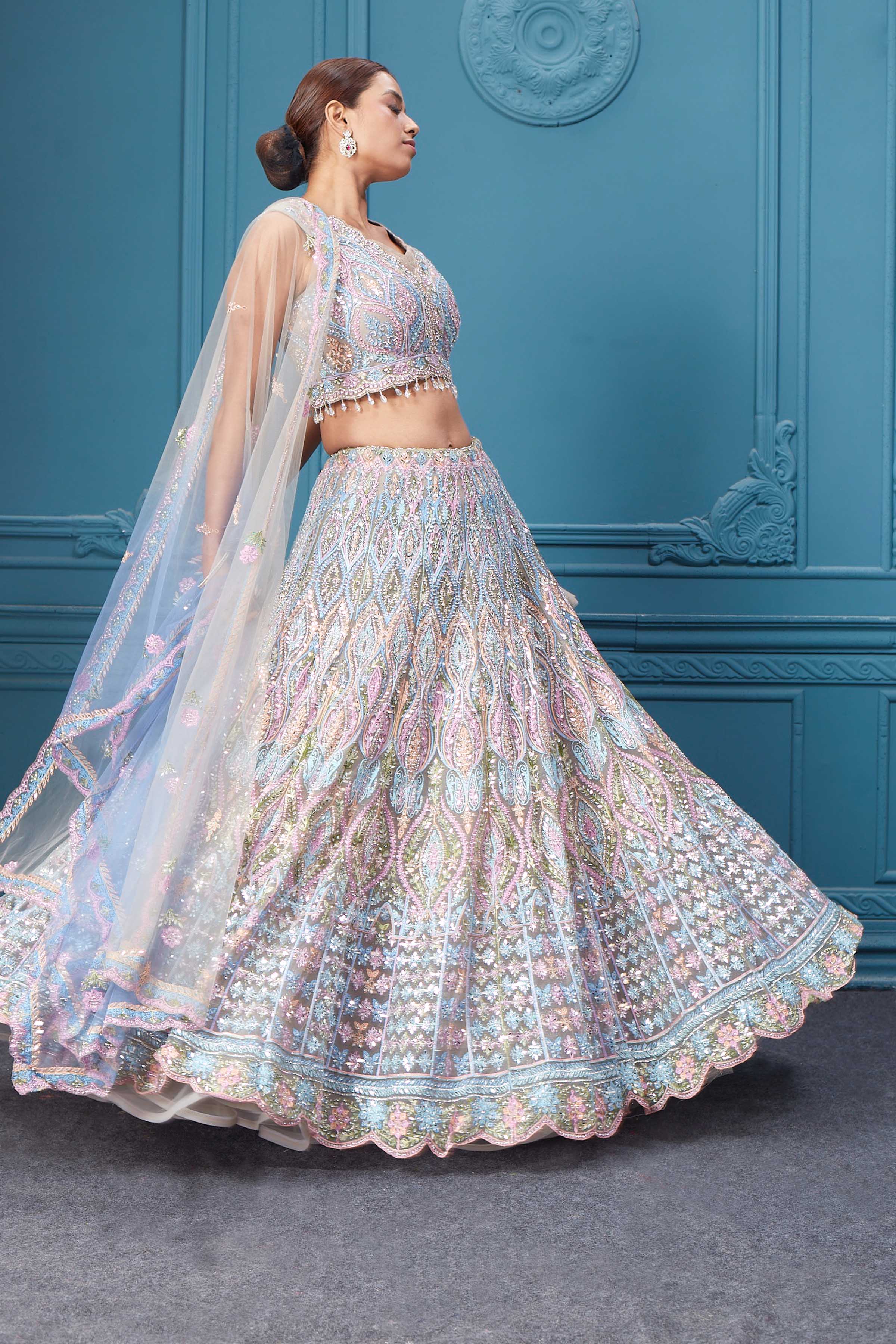 Shop this light blue and pink lehenga with heavy floral and sequin embroidery. Dazzle on weddings and special occasions with exquisite Indian designer dresses, sharara suits, Anarkali suits, bridal lehengas, and sharara suits from Pure Elegance Indian clothing store in the USA. Shop online from Pure Elegance.