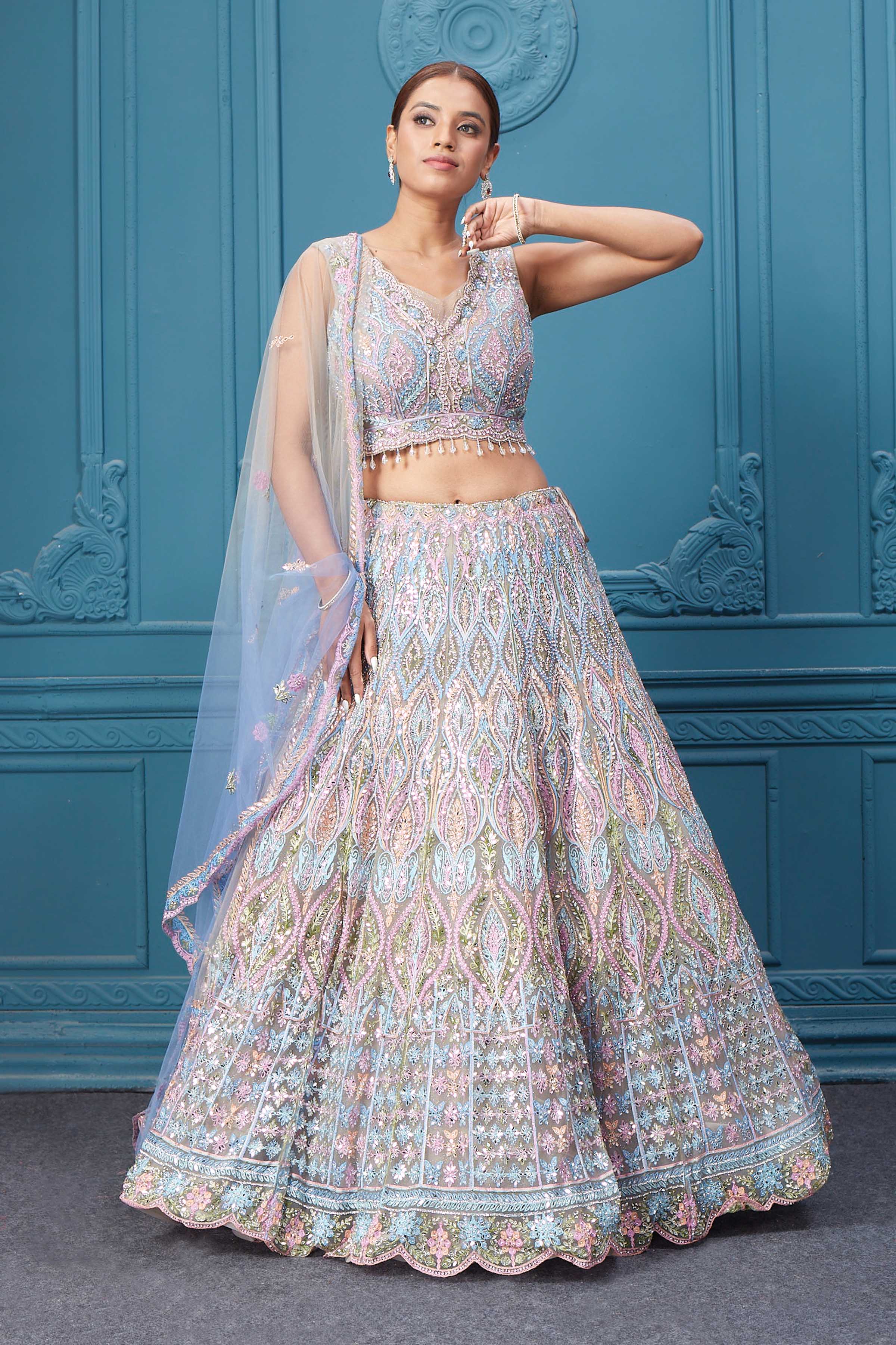 Shop this light blue and pink lehenga with heavy floral and sequin embroidery. Dazzle on weddings and special occasions with exquisite Indian designer dresses, sharara suits, Anarkali suits, bridal lehengas, and sharara suits from Pure Elegance Indian clothing store in the USA. Shop online from Pure Elegance.