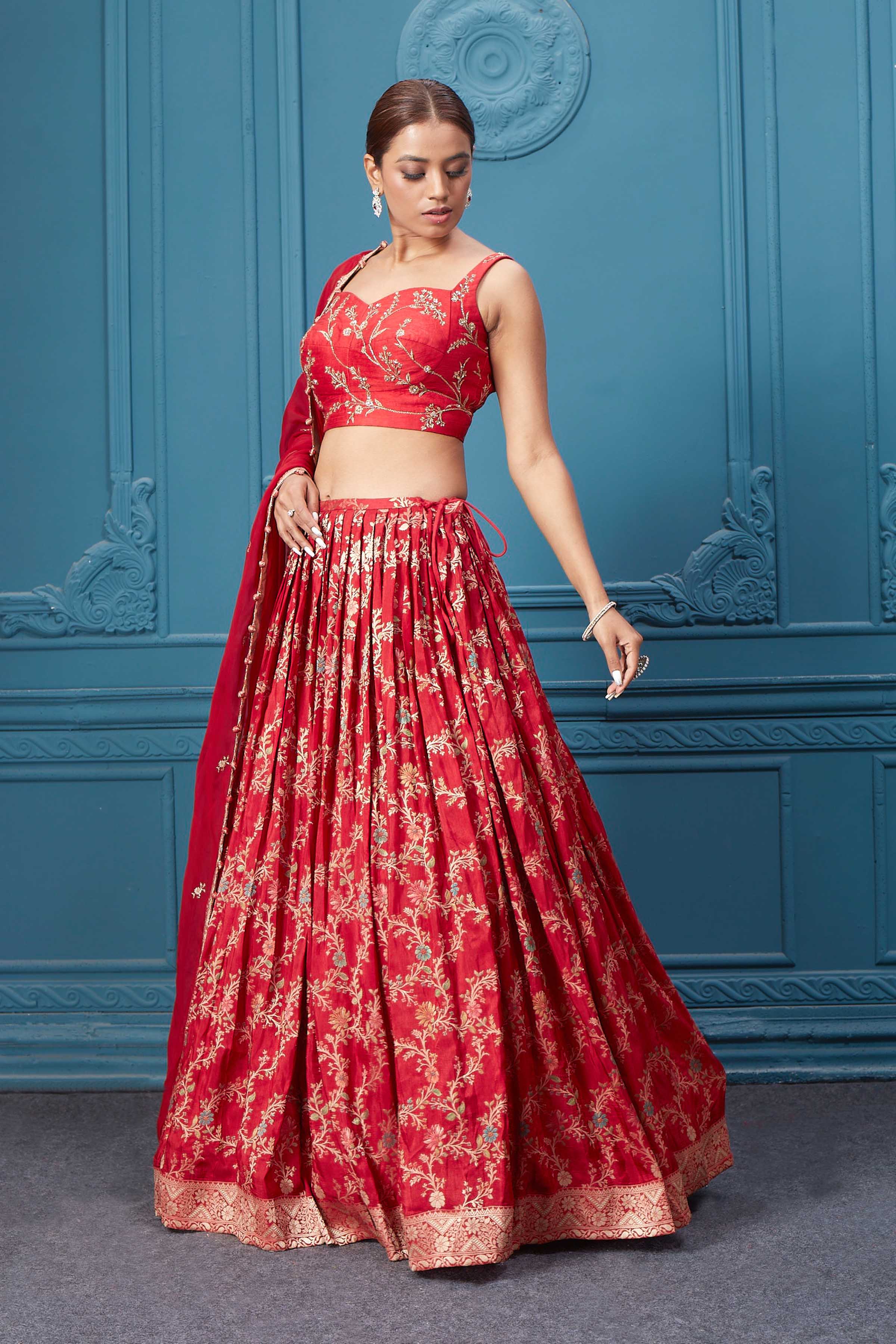 Shop this red lehenga with golden embroidery. Dazzle on weddings and special occasions with exquisite Indian designer dresses, sharara suits, Anarkali suits, bridal lehengas, and sharara suits from Pure Elegance Indian clothing store in the USA. Shop online from Pure Elegance.