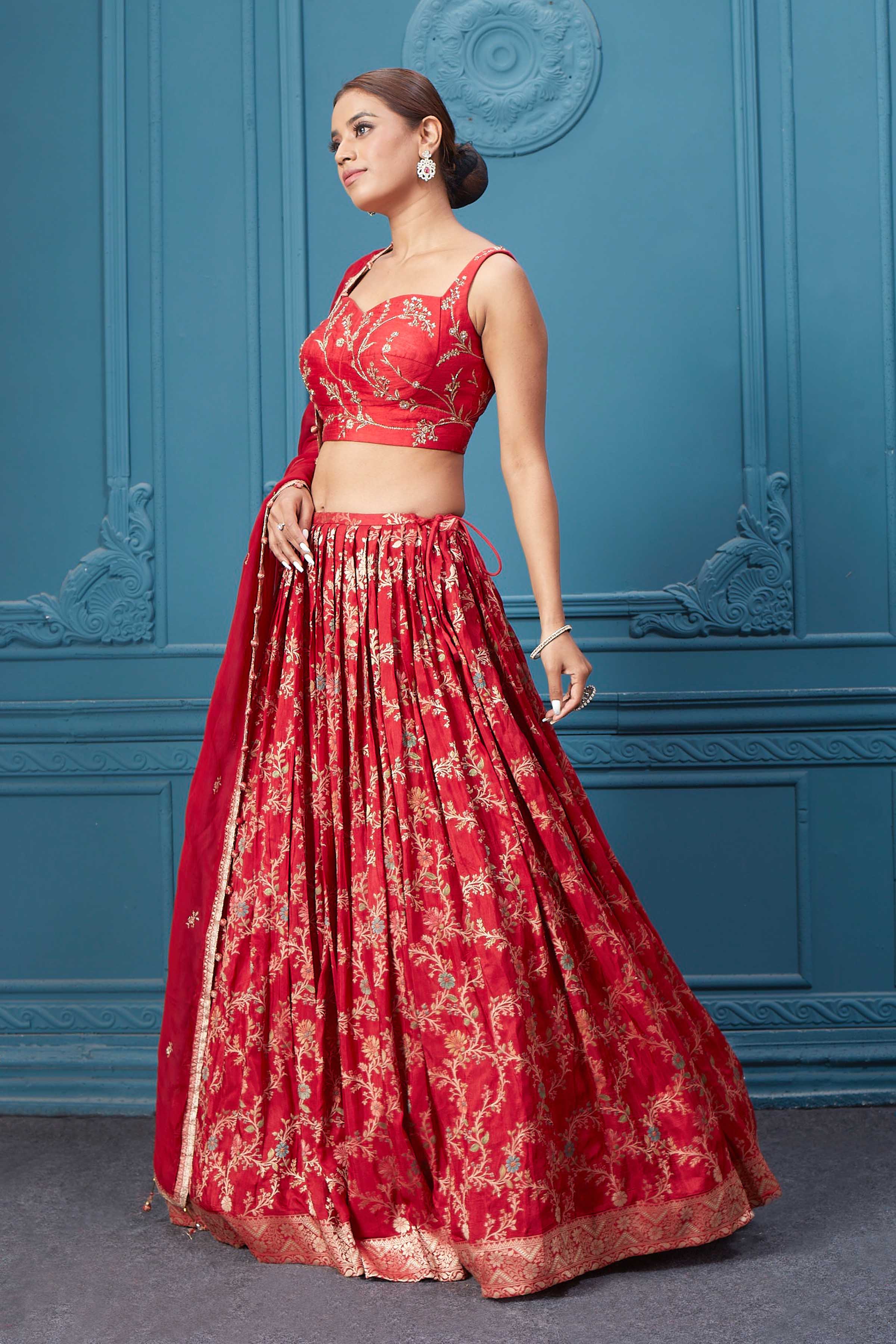 Shop this red lehenga with golden embroidery. Dazzle on weddings and special occasions with exquisite Indian designer dresses, sharara suits, Anarkali suits, bridal lehengas, and sharara suits from Pure Elegance Indian clothing store in the USA. Shop online from Pure Elegance.