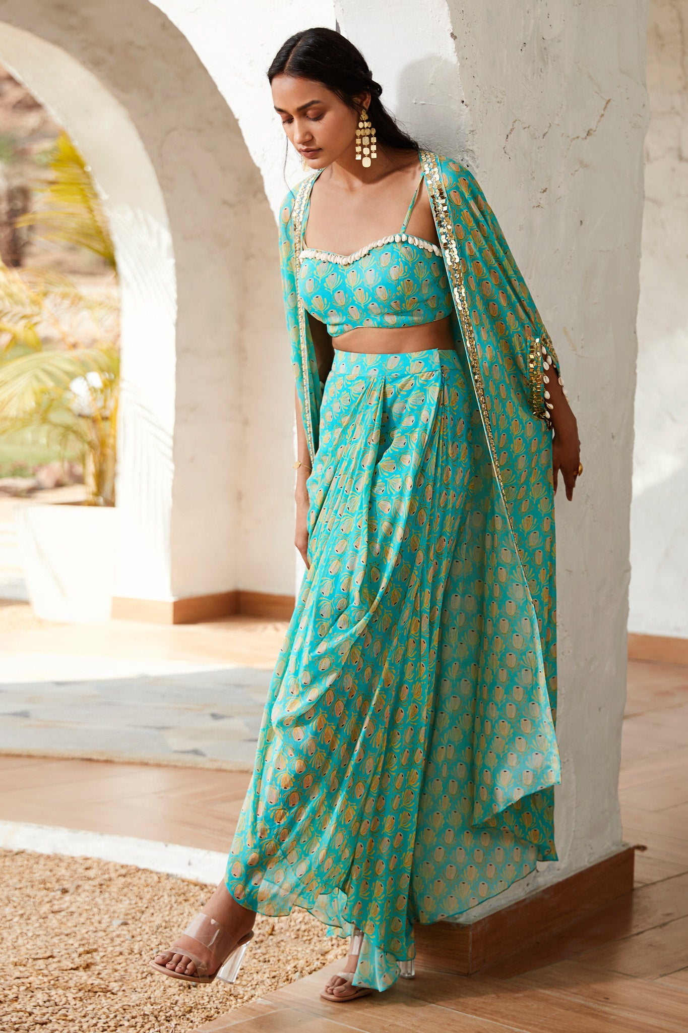 Buy a blue printed skirt set adorned with a strappy blouse & printed cape. Dazzle on weddings and special occasions with exquisite Indian designer dresses, sharara suits, Anarkali suits, and wedding lehengas from Pure Elegance Indian fashion store in the USA.