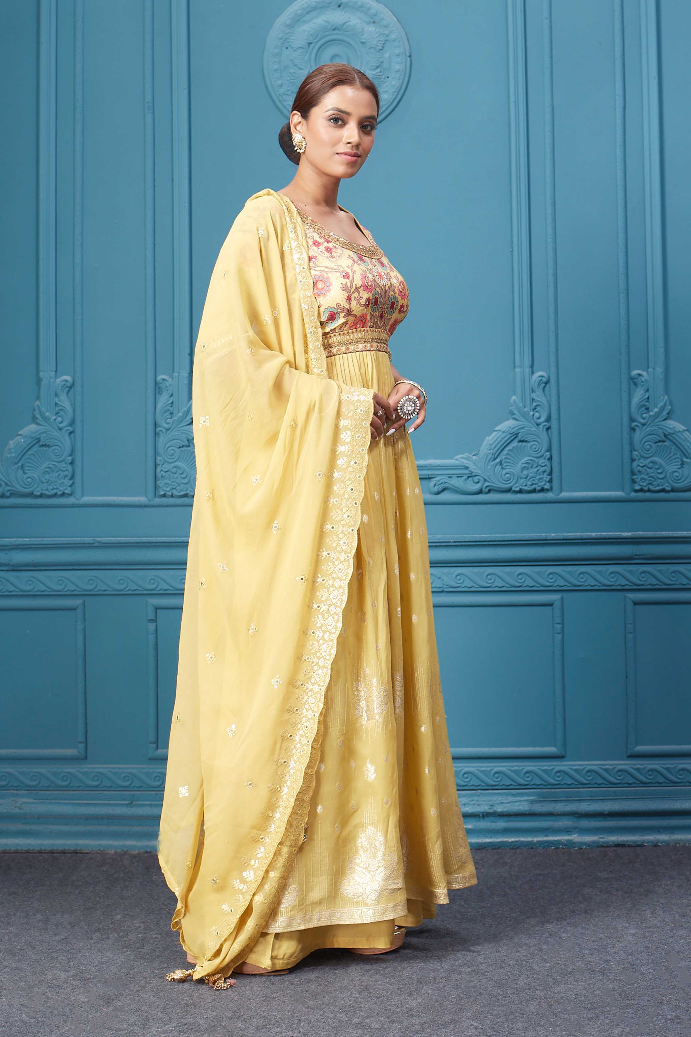 Shop a yellow naira cut suit set with mirror work and embroidered kurta, plazzo, 3/4th sleeves, and beautiful mirror work embroidered dupatta. Dazzle on special occasions with exquisite Indian designer dresses, sharara suits, Anarkali suits, bridal lehengas, and sharara suits from Pure Elegance Indian clothing store in the USA. Shop online from Pure Elegance.