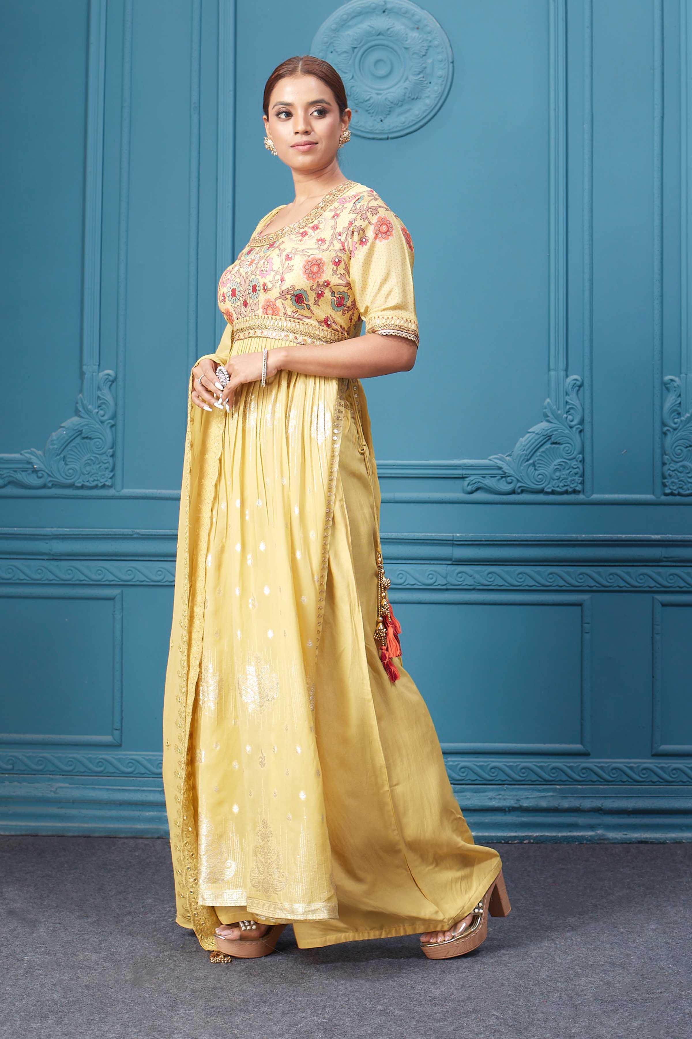 Shop a yellow naira cut suit set with mirror work and embroidered kurta, plazzo, 3/4th sleeves, and beautiful mirror work embroidered dupatta. Dazzle on special occasions with exquisite Indian designer dresses, sharara suits, Anarkali suits, bridal lehengas, and sharara suits from Pure Elegance Indian clothing store in the USA. Shop online from Pure Elegance.