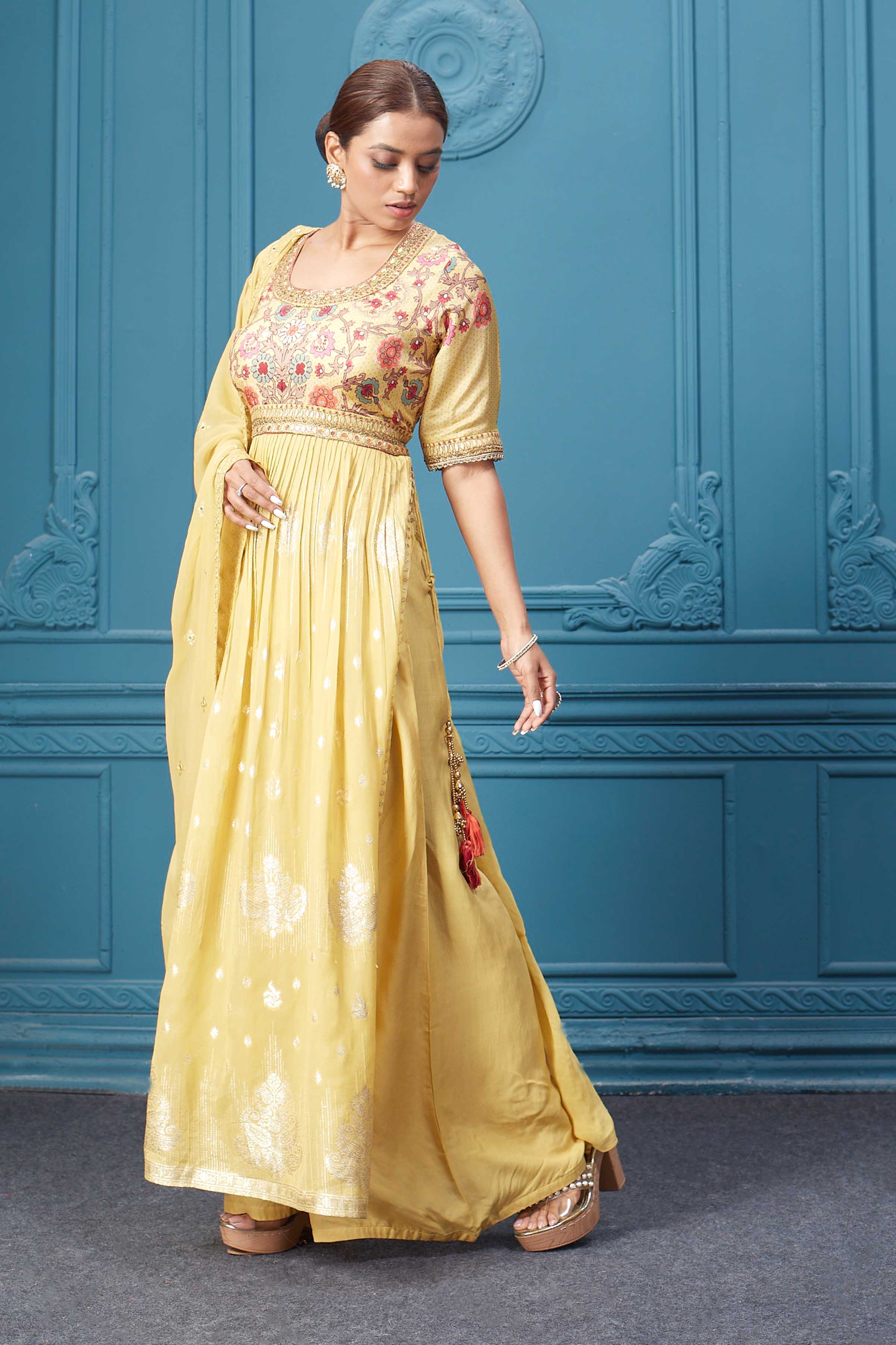 Shop a yellow naira cut suit set with mirror work and embroidered kurta, plazzo, 3/4th sleeves, and beautiful mirror work embroidered dupatta. Dazzle on special occasions with exquisite Indian designer dresses, sharara suits, Anarkali suits, bridal lehengas, and sharara suits from Pure Elegance Indian clothing store in the USA. Shop online from Pure Elegance.