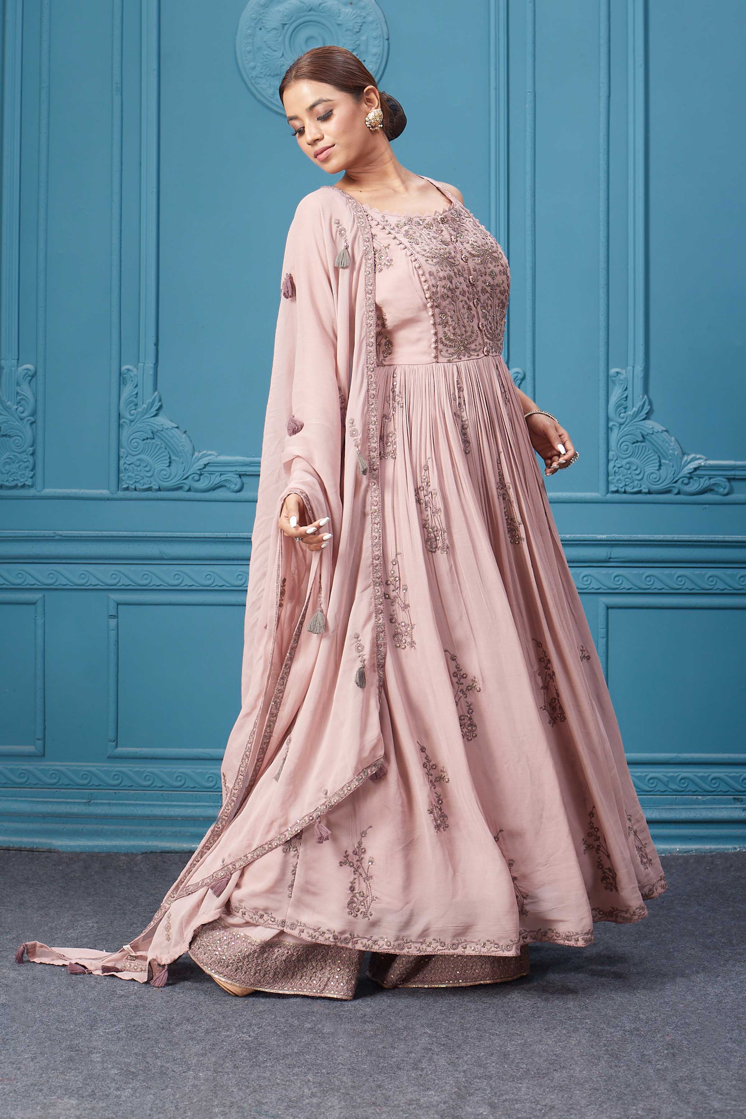 Shop a light pink embroidered sleeveless Anarkali kurta featuring mirror embroidery, embroidered bordered plazzo, and tassel work dupatta. Dazzle on special occasions with exquisite Indian designer dresses, sharara suits, Anarkali suits, bridal lehengas, and sharara suits from Pure Elegance Indian clothing store in the USA. Shop online from Pure Elegance.