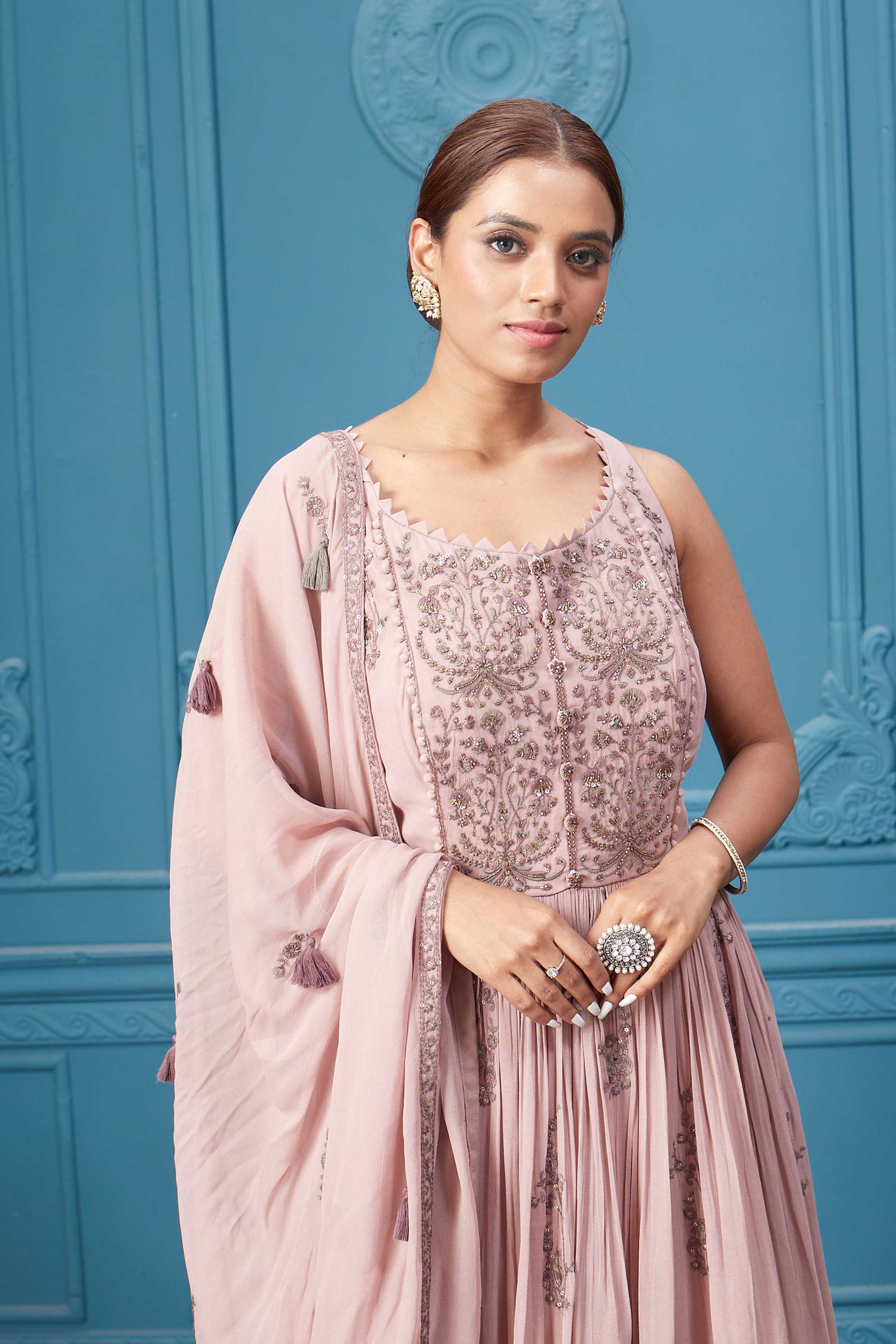 Shop a light pink embroidered sleeveless Anarkali kurta featuring mirror embroidery, embroidered bordered plazzo, and tassel work dupatta. Dazzle on special occasions with exquisite Indian designer dresses, sharara suits, Anarkali suits, bridal lehengas, and sharara suits from Pure Elegance Indian clothing store in the USA. Shop online from Pure Elegance.