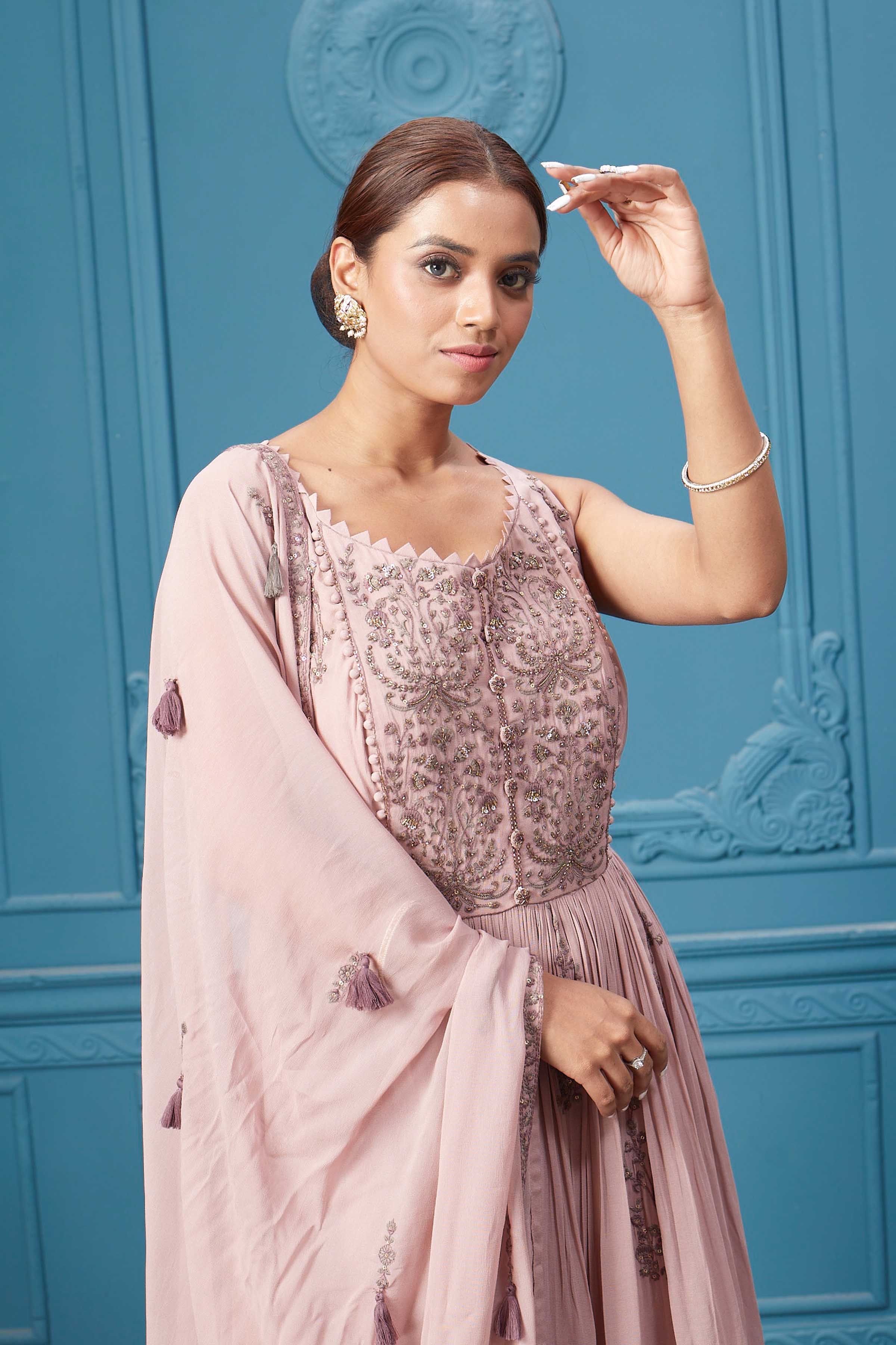 Shop a light pink embroidered sleeveless Anarkali kurta featuring mirror embroidery, embroidered bordered plazzo, and tassel work dupatta. Dazzle on special occasions with exquisite Indian designer dresses, sharara suits, Anarkali suits, bridal lehengas, and sharara suits from Pure Elegance Indian clothing store in the USA. Shop online from Pure Elegance.