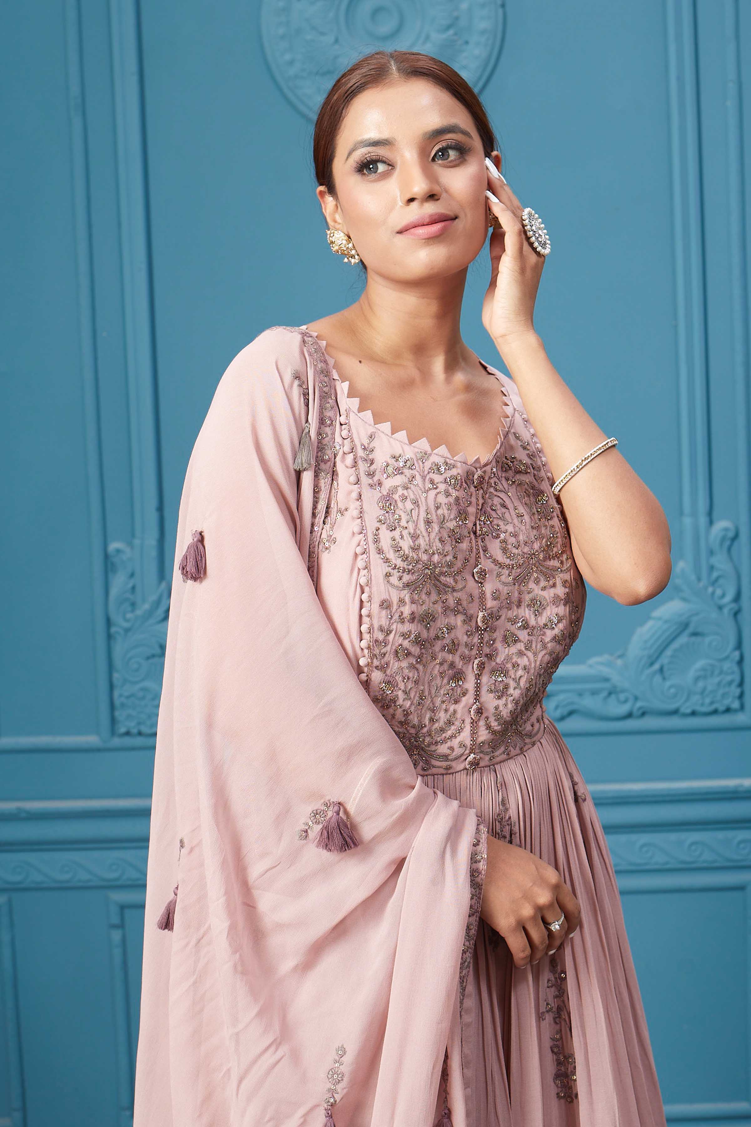 Shop a light pink embroidered sleeveless Anarkali kurta featuring mirror embroidery, embroidered bordered plazzo, and tassel work dupatta. Dazzle on special occasions with exquisite Indian designer dresses, sharara suits, Anarkali suits, bridal lehengas, and sharara suits from Pure Elegance Indian clothing store in the USA. Shop online from Pure Elegance.