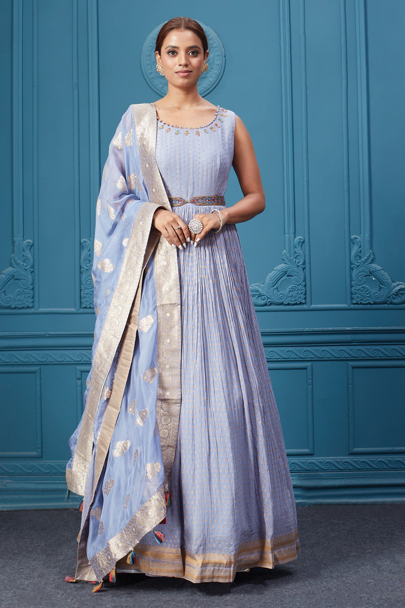 Buy a light blue embroidered sleeveless Anarkali kurta featuring embroidery, belt, and an embroidered dupatta with tassels. Dazzle on special occasions with exquisite Indian designer dresses, sharara suits, Anarkali suits, bridal lehengas, and sharara suits from Pure Elegance Indian clothing store in the USA. Shop online from Pure Elegance.