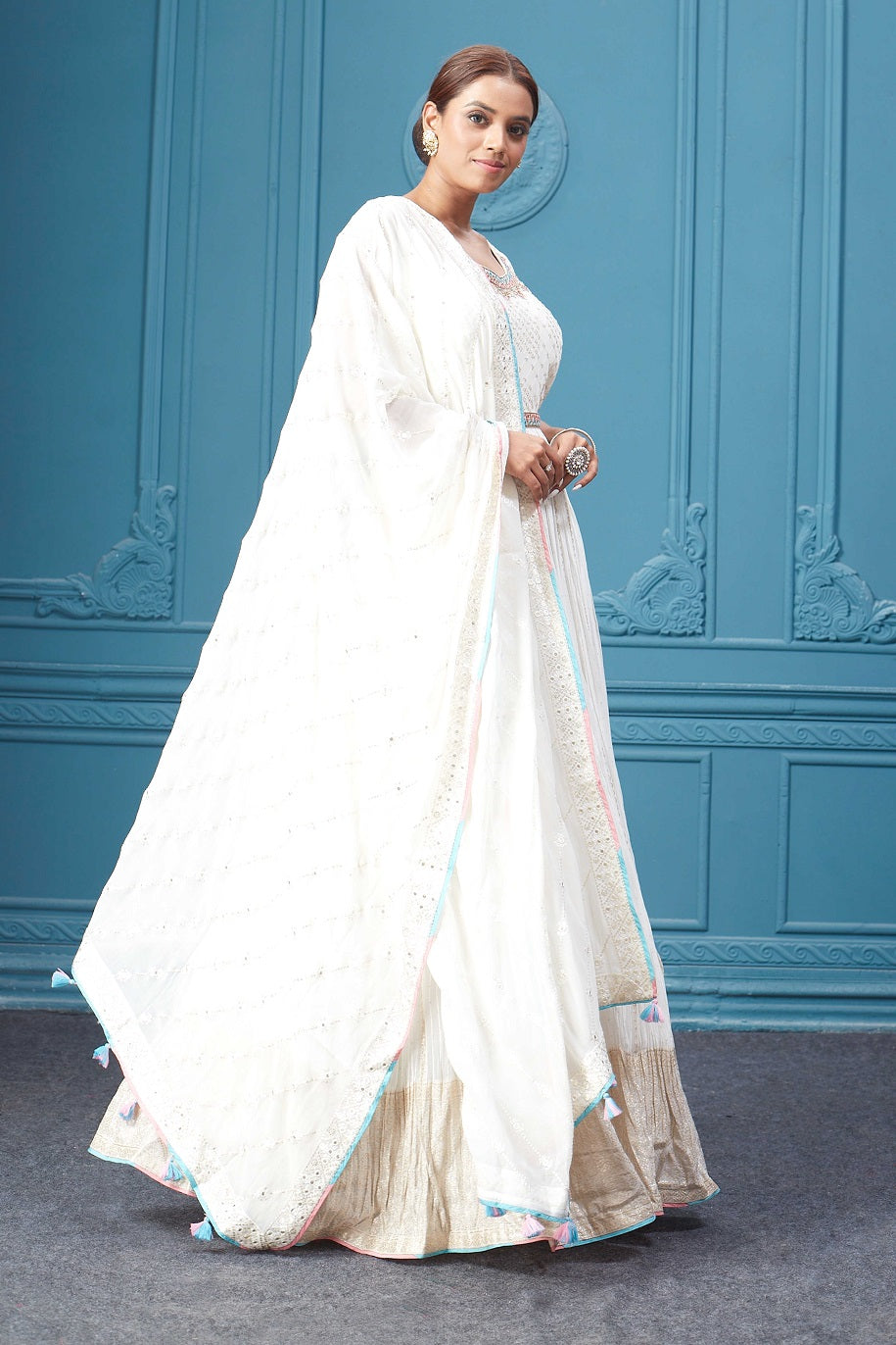 Buy a white embroidered sleeveless Anarkali kurta featuring mirror embroidery, embroidered borders, and a dupatta. Dazzle on special occasions with exquisite Indian designer dresses, sharara suits, Anarkali suits, bridal lehengas, and sharara suits from Pure Elegance Indian clothing store in the USA. Shop online from Pure Elegance.