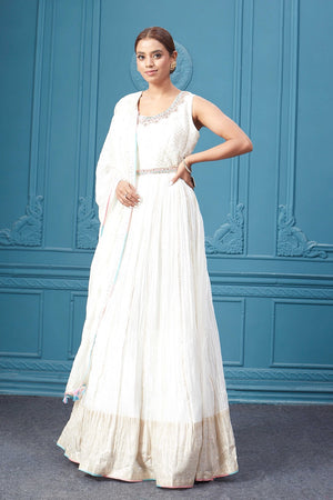 Buy a white embroidered sleeveless Anarkali kurta featuring mirror embroidery, embroidered borders, and a dupatta. Dazzle on special occasions with exquisite Indian designer dresses, sharara suits, Anarkali suits, bridal lehengas, and sharara suits from Pure Elegance Indian clothing store in the USA. Shop online from Pure Elegance.