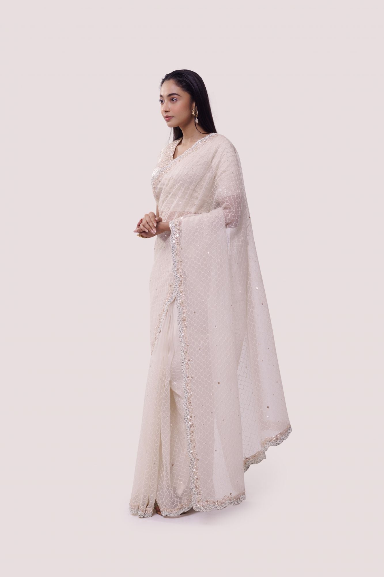 Shop a Beautiful off-white organza saree featuring threadwork and sparse embellishments. It comes with an embroidered blouse. Make a fashion statement on festive occasions and weddings with designer sarees, designer suits, Indian dresses, Anarkali suits, palazzo suits, designer gowns, sharara suits, and embroidered sarees from Pure Elegance Indian fashion store in the USA.