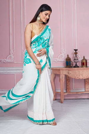 Buy off-white green floral crepe saree online in USA with scalloped border. Look your best on festive occasions in latest designer sarees, pure silk sarees, Kanjivaram silk saris, handwoven saris, tussar silk sarees, embroidered saris from Pure Elegance Indian clothing store in USA.-side