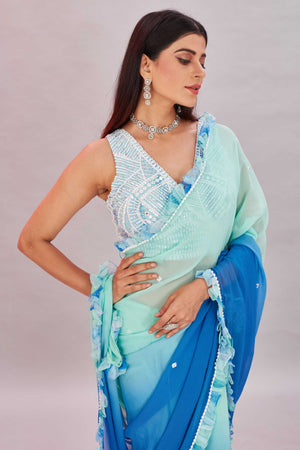 Shop beautiful ombre blue georgette ruffle sari online in USA with embroidered blouse. Look your best on festive occasions in latest designer saris, pure silk sarees, Kanjivaram silk sarees, handwoven saris, tussar silk sarees, embroidered saris from Pure Elegance Indian clothing store in USA.-closeup