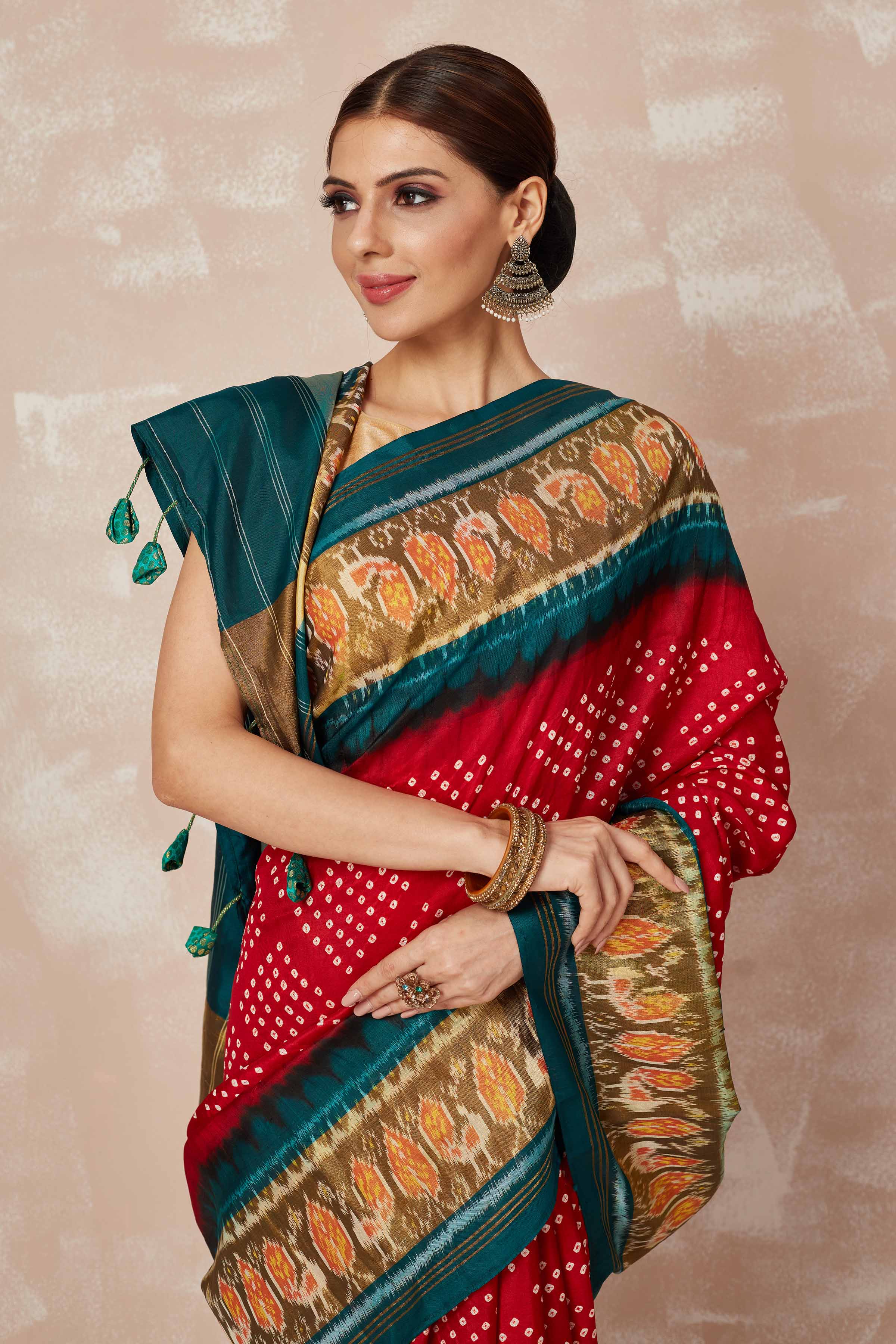 Buy red Patola bandhej saree online in USA with brown green border. Look your best on festive occasions in latest designer sarees, pure silk sarees, Kanjivaram silk saris, handwoven saris, tussar silk sarees, embroidered saris from Pure Elegance Indian clothing store in USA.-closeup