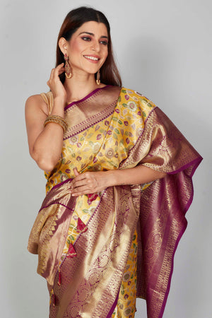 Buy yellow floral Kanjeevaram silk saree online in USA with purple zari border. Look your best on festive occasions in latest designer saris, pure silk saris, Kanjivaram silk sarees, handwoven saris, tussar silk sarees, embroidered saris from Pure Elegance Indian clothing store in USA.-closeup