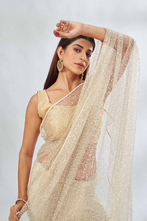 Buy cream designer net sari online in USA with overall embroidery. Look your best on festive occasions in latest designer saris, pure silk saris, Kanjivaram silk sarees, handwoven saris, tussar silk sarees, linen sarees,  embroidered sarees from Pure Elegance Indian clothing store in USA.-closeup