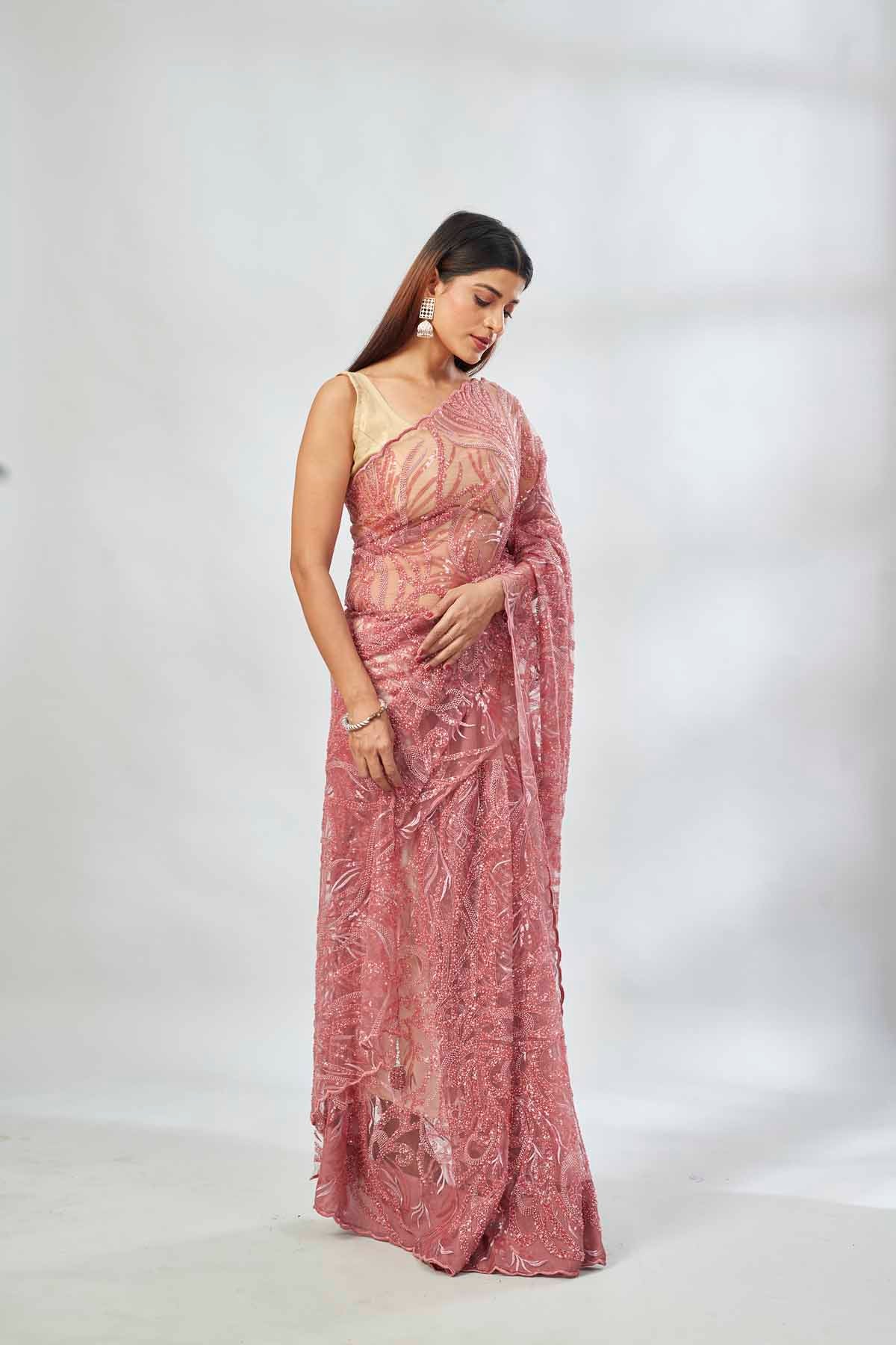 Shop dusty pink embroidered lace net saree online in USA with blouse. Look your best on festive occasions in latest designer saris, pure silk saris, Kanjivaram silk sarees, handwoven saris, tussar silk sarees, linen sarees,  embroidered sarees from Pure Elegance Indian clothing store in USA.-saree