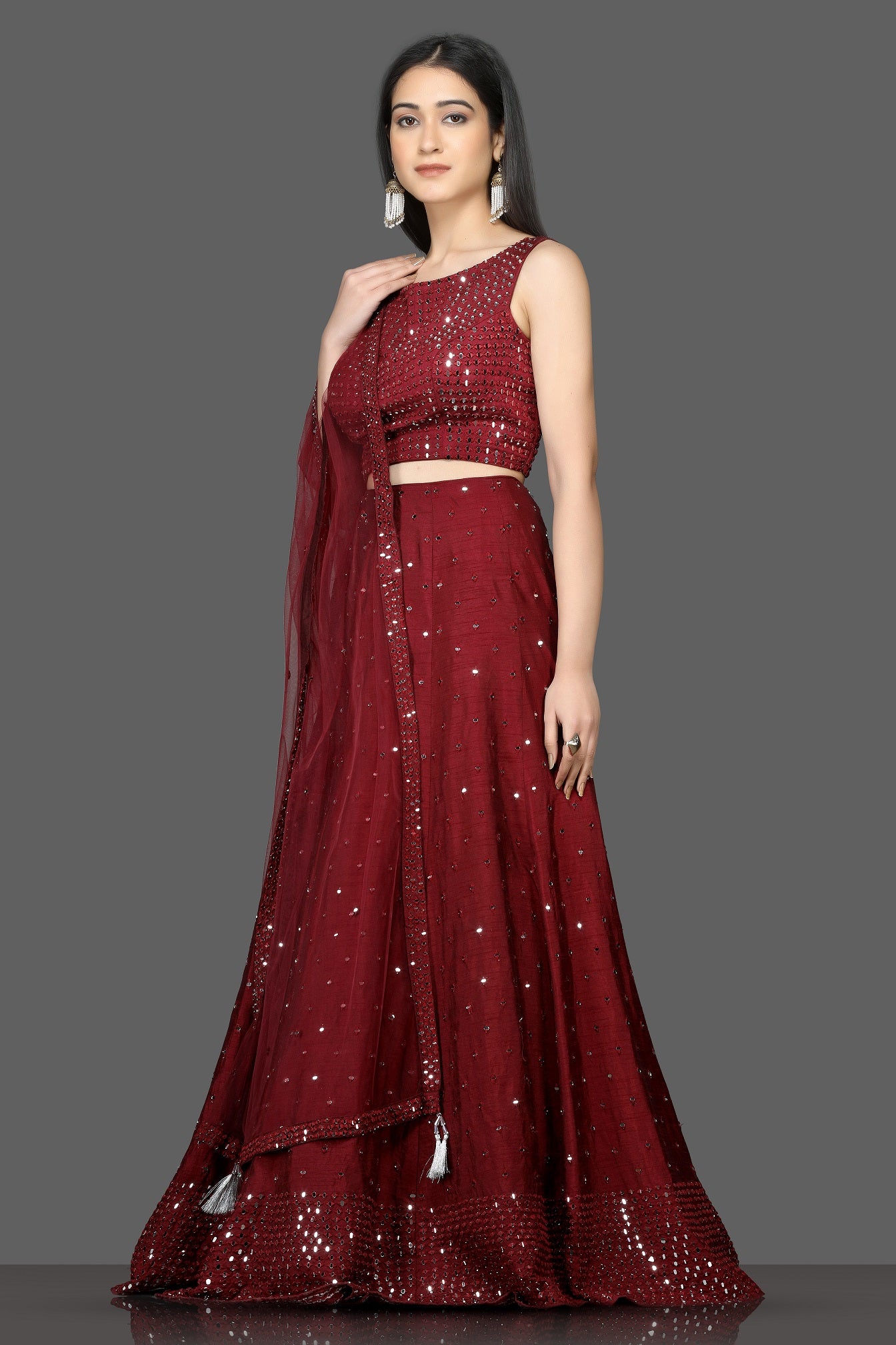 Buy wine color mirror work designer lehenga online in USA with net dupatta. Flaunt your sartorial choices on special occasions with beautiful designer gowns, Anarkali suits, traditional salwar suits, Indian lehengas from Pure Elegance Indian fashion boutique in USA. -left