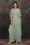 Buy sage green embroidered crop top with draped skirt online in USA and shrug. Dazzle at sangeet and wedding occasions in this beautiful designer lehengas, Anarkali suits, sharara suit, bridal gowns, bridal lehengas from Pure Elegance Indian fashion store in USA.-full view