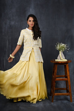 Buy this designer satin organza lehenga. This asymmetrical layered piece in lemon&white is embellished with a fully embroidered blouse and mesmerizing dori work. A fully embroidery satin blouse makes this a sophisticated piece of luxury that will captivate you in its calmness and serenity. Style this set with a pair of diamond earrings and solid pumps to finish the look from Pure Elegance Indian clothing store in USA online now.-Full view.