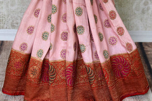 Grace with finesse in this gorgeous pink muga banarsi silk saree. Woven with pretty motifs all-over, it features a rich red zari border and complemented well with a contrasting red zari blouse to enrich the ensemble. Shop designer silk sarees, georgette sari, organza sari online or visit Pure Elegance store, USA.-pleats