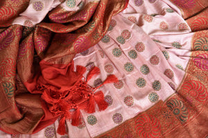 Grace with finesse in this gorgeous pink muga banarsi silk saree. Woven with pretty motifs all-over, it features a rich red zari border and complemented well with a contrasting red zari blouse to enrich the ensemble. Shop designer silk sarees, georgette sari, organza sari online or visit Pure Elegance store, USA.-details