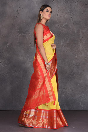 Photo of A Marathi bride in a yellow saree with red border