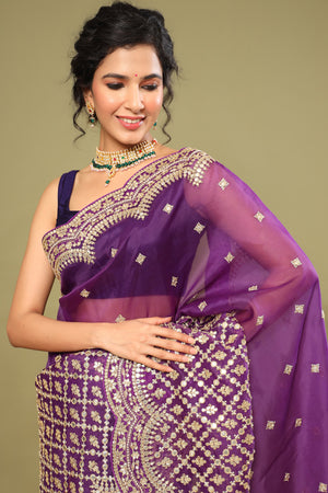 Buy purple organza silk saree online in USA with embroidered scalloped border. Make a fashion statement at weddings with stunning designer sarees, embroidered sarees with blouse, wedding sarees, handloom sarees from Pure Elegance Indian fashion store in USA.-closeup